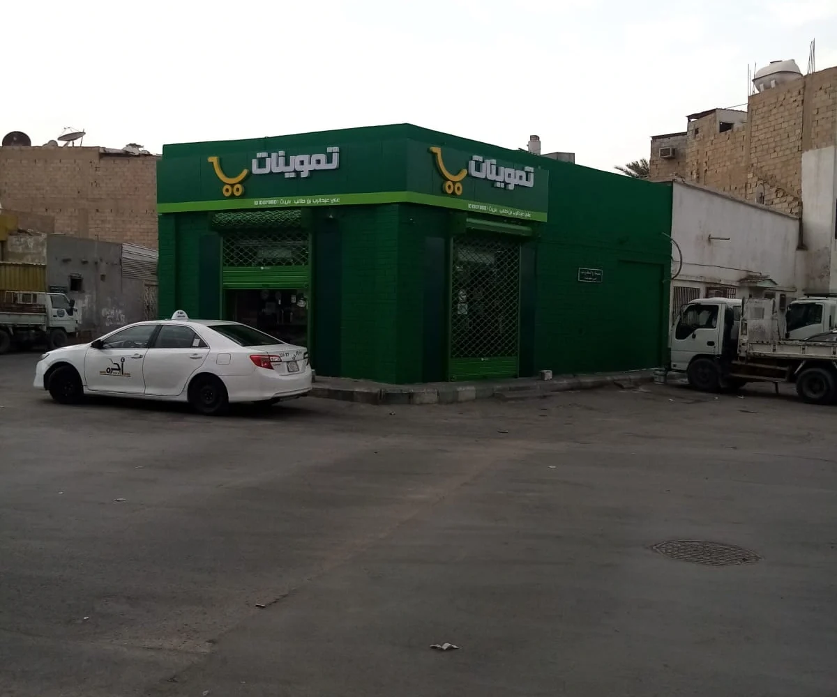 واجهة محل تموينات باللون الأخضر بعد الانتهاء من أعمال الدهان الخارجي في الرياض.